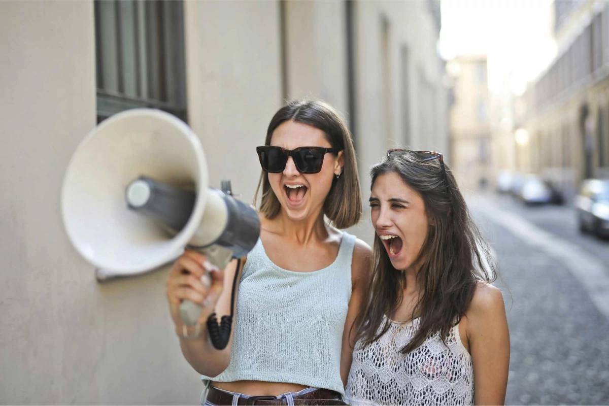 Deux femmes crient dans un haut-parleur